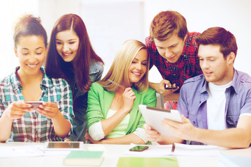 students looking at smartphones and tablet pc