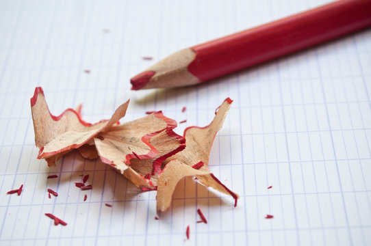 crayon de couleur rouge et taillure sur cahier d'&eacute;colier