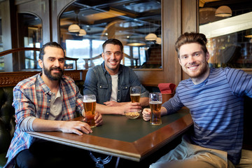 Fototapeta na wymiar happy male friends drinking beer at bar or pub