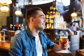 happy man drinking beer at bar or pub