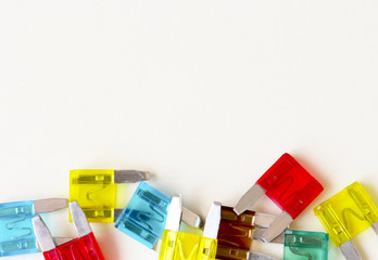 The fuse of the car. Pile of colorful electric automotive fuses or circuit breakers, on a light...