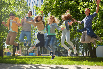 happy teenage students or friends jumping outdoors