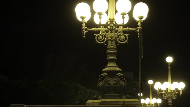 Beautiful lampposts at night over bridge, close up, RL Pan