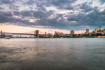 Naklejka premium Brooklyn Bridge and lower Manhattan at dusk viewed from the Brooklyn Bridge Park in New York City.