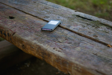 Forgotten cell phone (mobile phone) on a public bench
