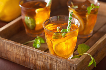 ice tea with lemon and mint on dark rustic background