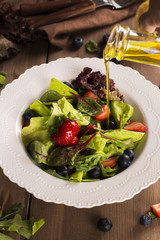 Fresh summer salad with berries and green leaves