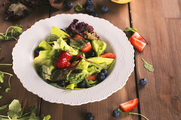 Fresh summer salad with berries and green leaves