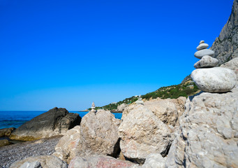 Small pyramids are on the big rocks by the Black sea.