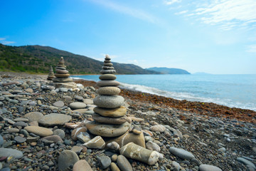 The three pyramids of sea pebbles on the beach .