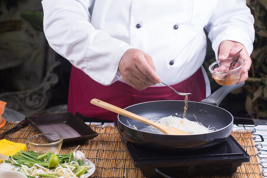 Chef putting tamarine sauce for cooking Pad Thai