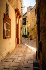 Fototapeta na wymiar Valletta iconic narrow city streets at sunset