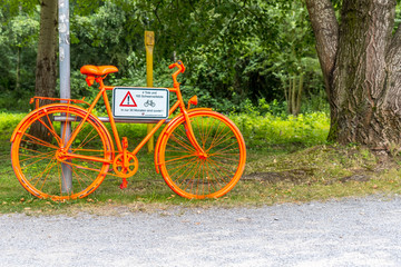 Fototapeta premium Oranges Fahrrad mit weisser Warntafel
