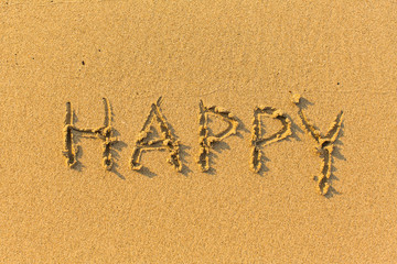 Happy - inscription on sand beach.