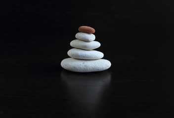 Fototapeta na wymiar a set of smooth stones on a black background, stacked in the order