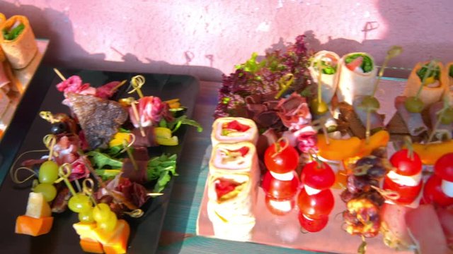 beautifully decorated buffet table, canapés, rolls, vegetables, fish