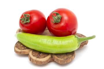 Isolated tomatoes and hot pepper on a wooden stand