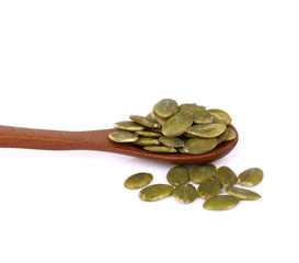 Pumpkin seeds in wooden spoon on white background.
