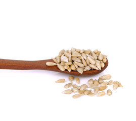 sun-flower seeds in wooden spoon on a white background