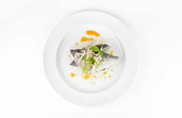 Crédence de cuisine en verre imprimé Poisson Poisson Dorado au pamplemousse et salade verte sur une assiette sur fond blanc, vue de dessus