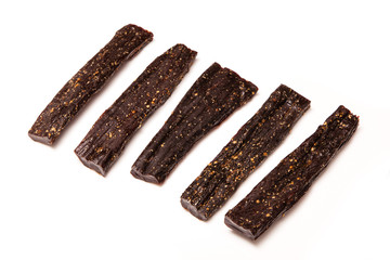 Biltong South african dried beef jerky isolated on a white studio background.