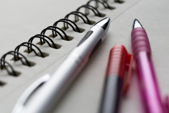 Pens on notepad. Closeup detail.