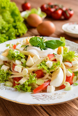 Spaghetti pasta salad with tomato, lettuce, egg, Feta cheese, green onion and sour cream