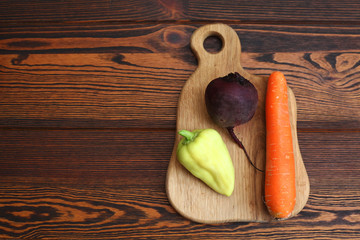 морковь, зеленый перец, свекла на деревянной доске на деревянном столе. Набор овощей для свежевыжатого сока и смузи