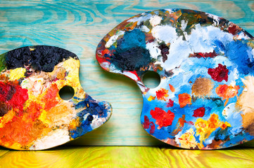 Fototapeta premium Painting palettes on colorful wooden background