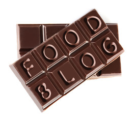 Black chocolate pieces isolated on white background. Food blog concept