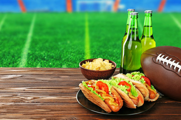 Beer bottles, ball and snack on football field background © Africa Studio