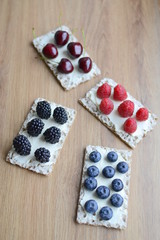 Healthy sandwiches with berries on wooden background