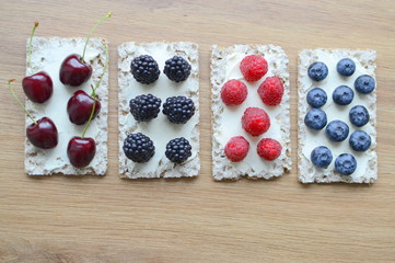 Healthy sandwiches with berries on wooden background