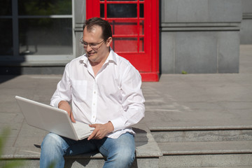 Business man on  red classic English telephone box