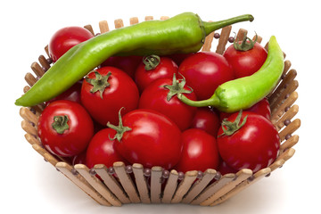 Isolated red tomatoes and hot green pepper in a wooden vase