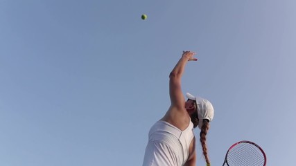 Beautiful female tennis player serving outdoor - Powered by Adobe