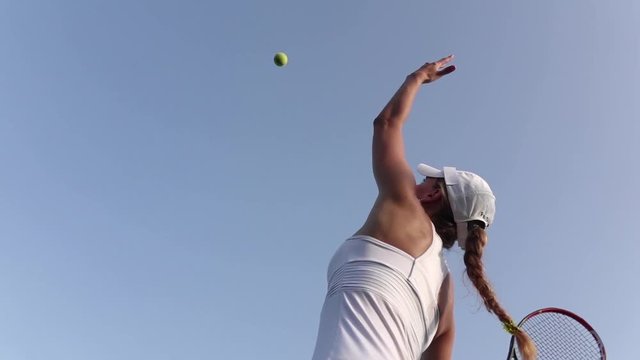 Girl serving tennis ball. Tennis player. Slow motion