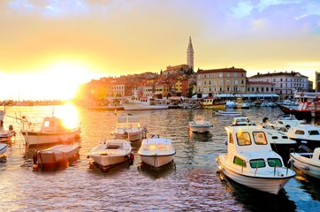 Old Town and harbor with boats and vibrant sunset over the sea, Rovinj, Croatia
