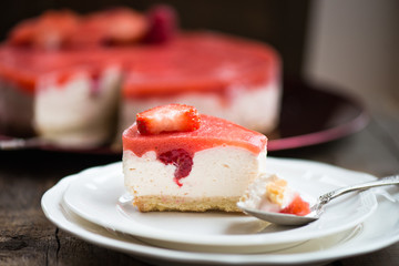 Homebaked Summer Berry Cheesecake with Jelly on the Top made from Raspberries and Strawberries on White Plates