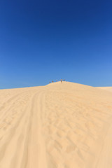 Fototapeta na wymiar people in desert - white sand dune in mui ne , vietnam