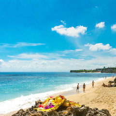 Hindu offering placed ontop of a rock with tourists enjoying the
