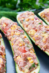 Raw courgettes stuffed with meat and vegetables