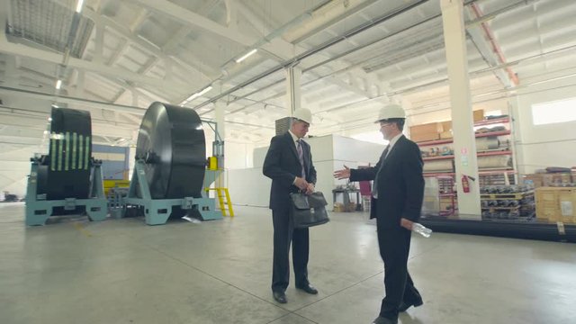 Partners greet each other on manufacturing plant