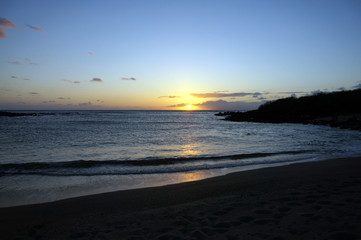 Beautiful Sunset over the ocean with waves moving to Beach
