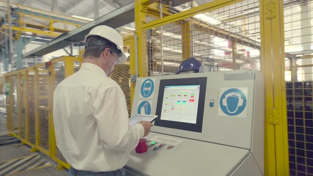 Engineer is checking settings of CNC machine