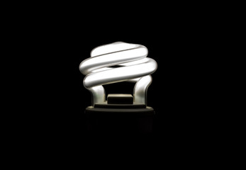 Modern energy-saving lightbulb burning isolated on black background