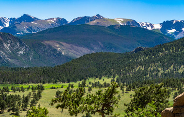Fototapeta na wymiar view of the meadows and foot hills below the snow dotted peaks of the Rocky Mountains in Colorado 