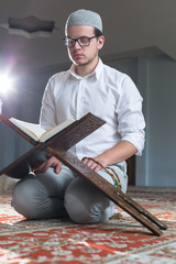 a muslim man is reading quran.