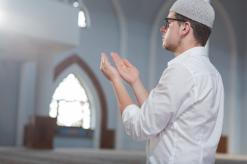 Religious muslim man praying inside the mosque