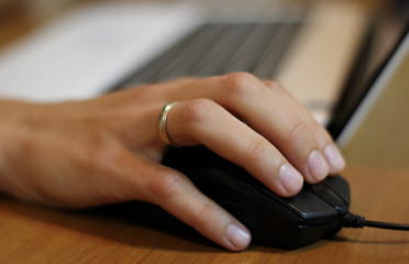 Woman’s hand on the computer mouse at works